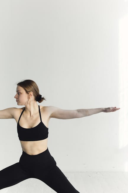 Woman practicing a graceful yoga pose on a mat in a bright studio